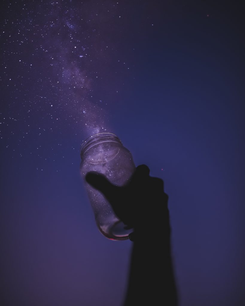 How I got here. A hand holding a jar catching dreams