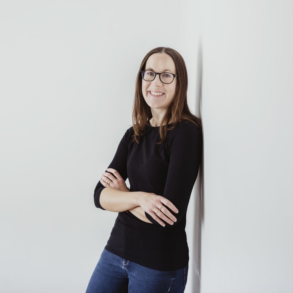 Headshot of Jude Wharton standing against a white wall