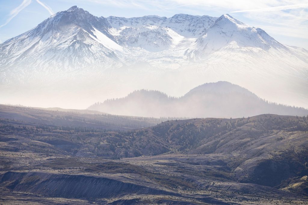 A big mountain in the distance with a smaller hill in the foreground